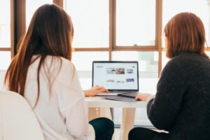 Two women using ImageMagick and looking at images on a computer